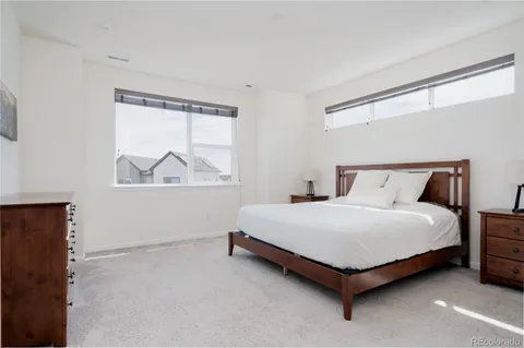 a large bed sitting in a bedroom next to a window