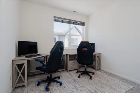 a view of a workspace with furniture and a window