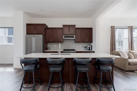 a kitchen with stainless steel appliances granite countertop a sink a stove a refrigerator and cabinets