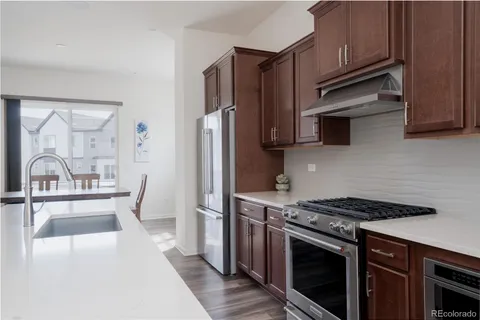 a kitchen with stainless steel appliances granite countertop a stove a sink and a refrigerator