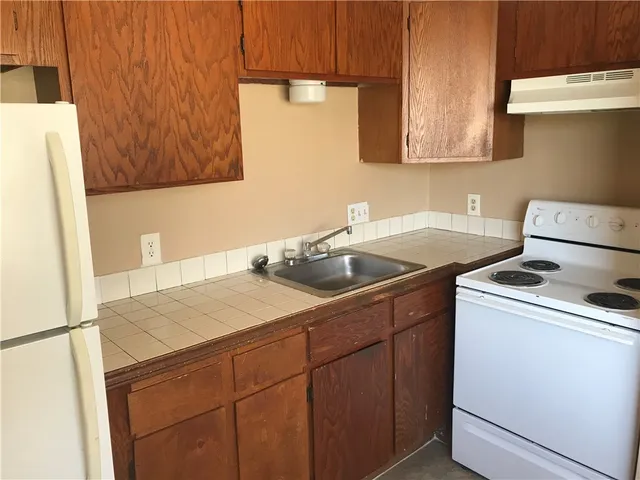 a kitchen with a sink a stove and a refrigerator