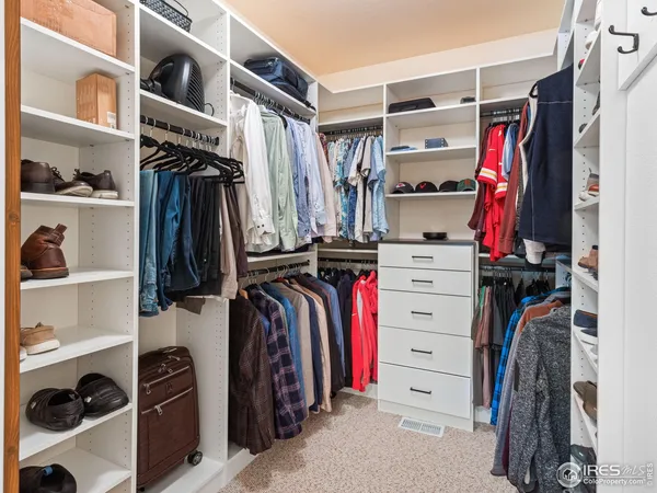 a view of walk in closet with clothes and shoes