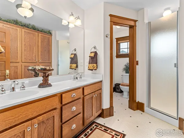a spacious bathroom with a double vanity sink a mirror and a shower