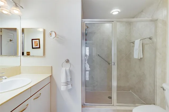 a bathroom with a shower sink vanity and toilet
