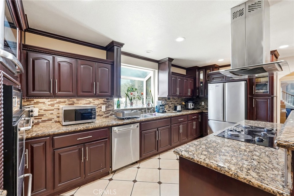 8630 Sharp Avenue Sun Valley, CA 91352 - Photo 11 of 62 a kitchen with stainless steel appliances granite countertop wooden cabinets a stove top oven and granite counter tops