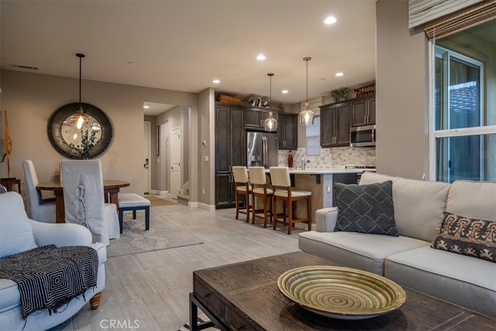 1170 Spring Azure Way, Unit 45 Nipomo, CA 93444 - Photo 4 of 43 a living room with furniture a clock and a chandelier