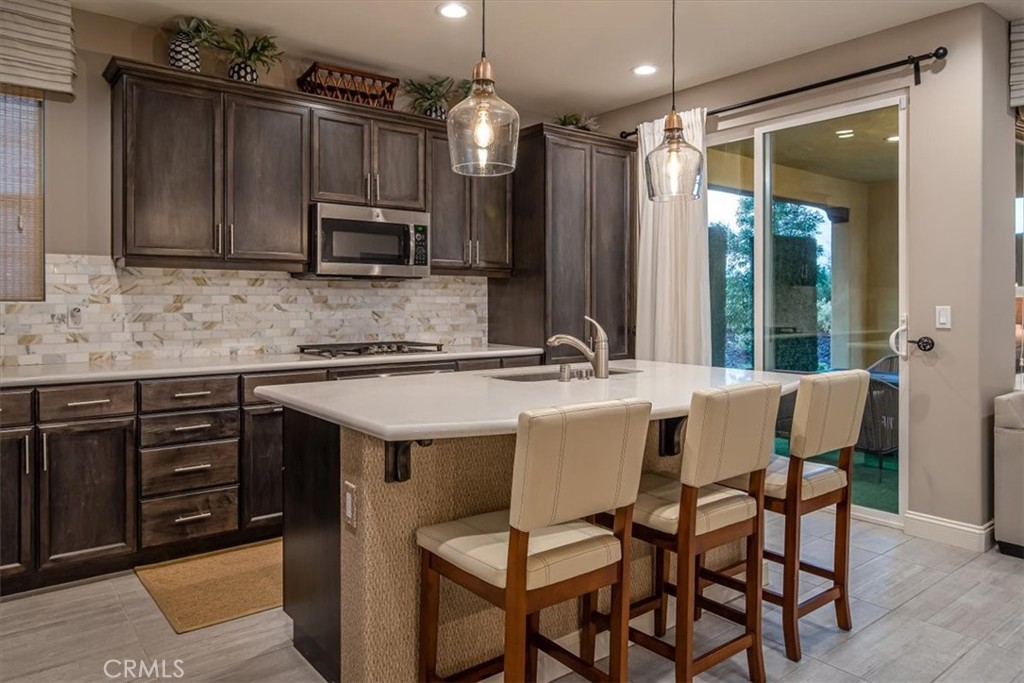 1170 Spring Azure Way, Unit 45 Nipomo, CA 93444 - Photo 5 of 43 a kitchen with a table chairs sink and cabinets