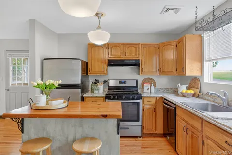 a kitchen with stainless steel appliances granite countertop a sink a stove top oven a counter space and cabinets