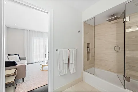 a kitchen with stainless steel appliances kitchen island granite countertop a refrigerator a sink a stove and white cabinets with wooden floor