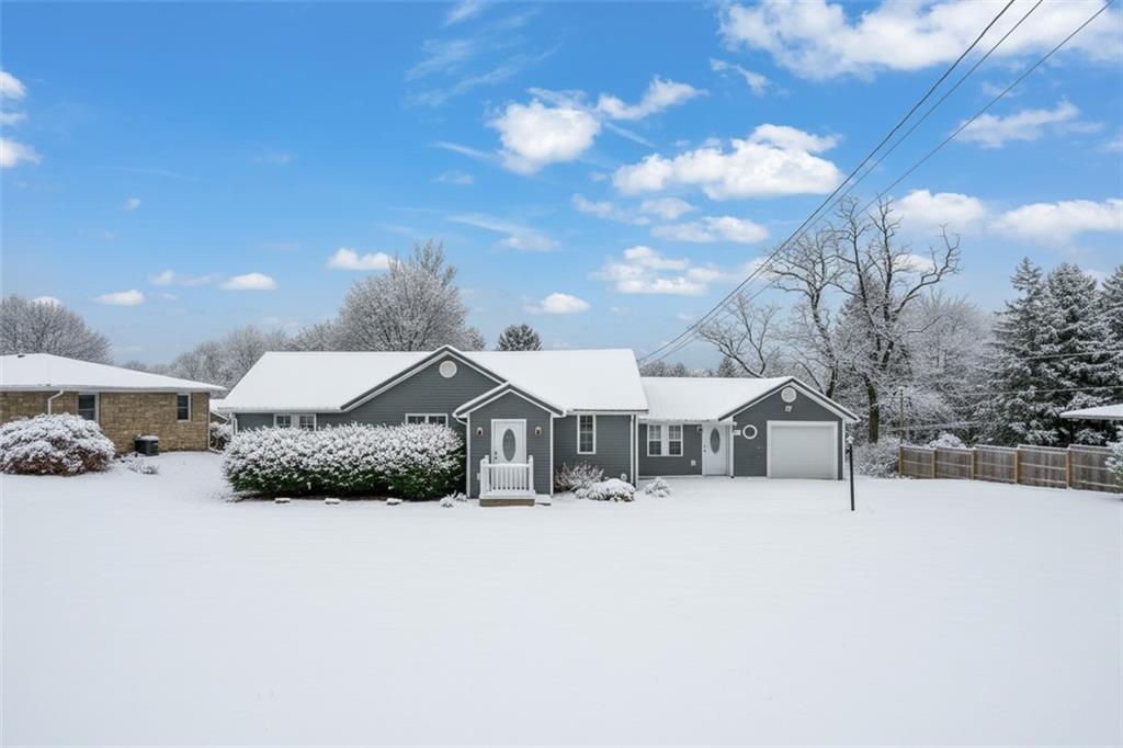 a front view of a house with a yard covered in snow
