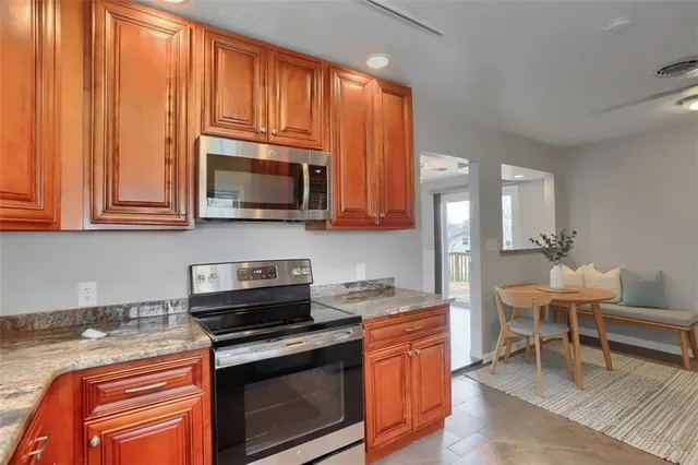 a kitchen with stainless steel appliances granite countertop a stove a sink and a microwave