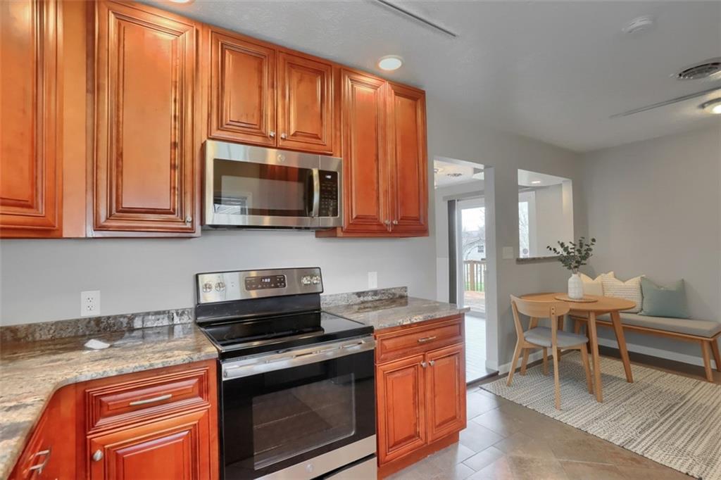 110 Oakville Road Beaver Falls, PA 15010 - Photo 20 of 48 a kitchen with stainless steel appliances granite countertop a stove a sink and a microwave