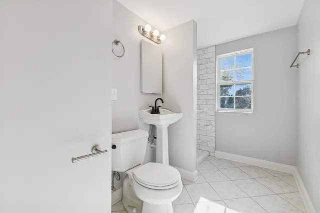 a bathroom with a sink toilet and a mirror