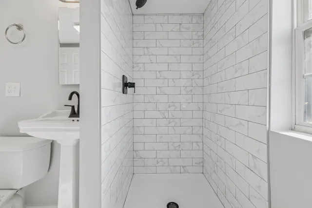a bathroom with a sink a toilet and shower