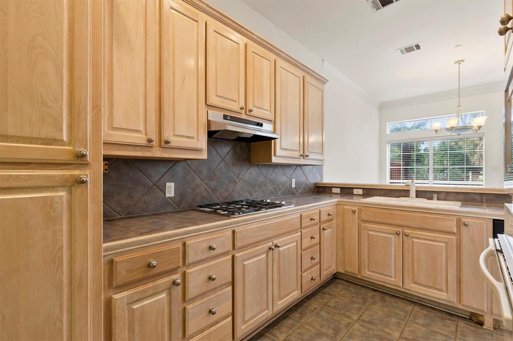 4106 Oberlin Way Addison, TX 75001 - Photo 6 of 17 a kitchen with granite countertop white cabinets and white appliances