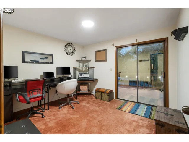 a view of a workspace with furniture and a window