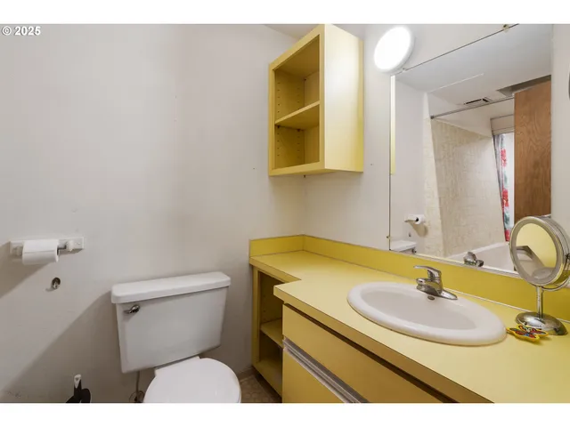 a living room with furniture a flat screen tv and next to a window