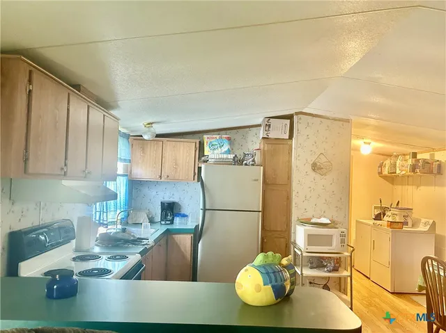 a kitchen with stainless steel appliances granite countertop a sink refrigerator and cabinets