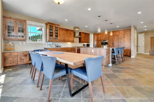 a dining hall with stainless steel appliances a dining table and chairs