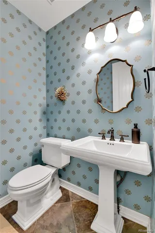 a bathroom with a sink a toilet and a mirror