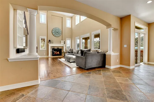 a living room with furniture a fireplace and a floor to ceiling window