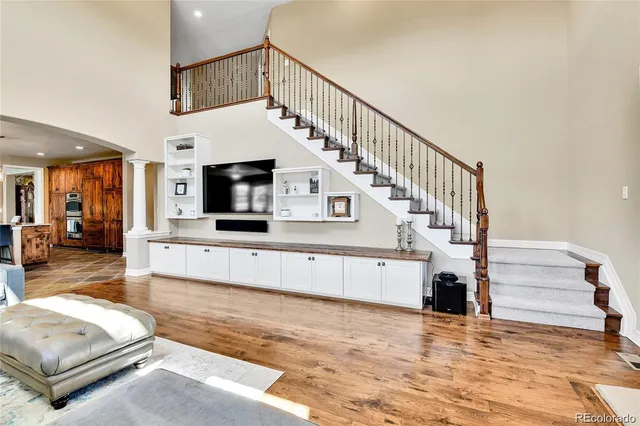 a living room with a balcony furniture and a flat screen tv