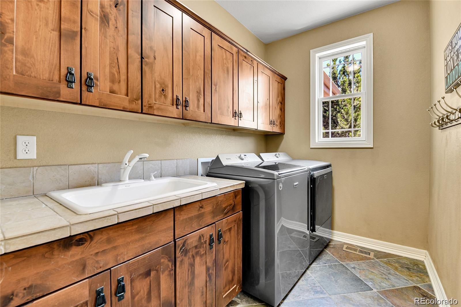 791 Elk Rest Road Evergreen, CO 80439 - Photo 19 of 39 a utility room with stainless steel appliances granite countertop a sink a stove and dishwasher with wooden floor