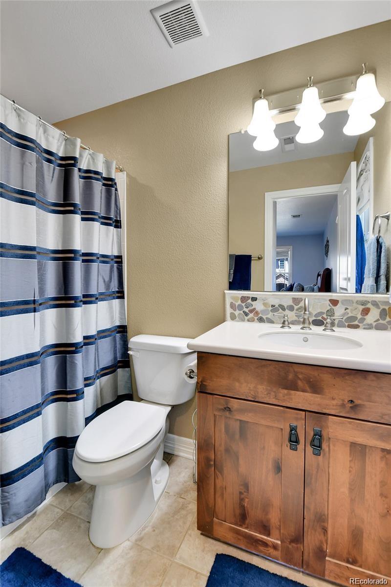 791 Elk Rest Road Evergreen, CO 80439 - Photo 22 of 39 a bathroom with a sink a toilet and a mirror