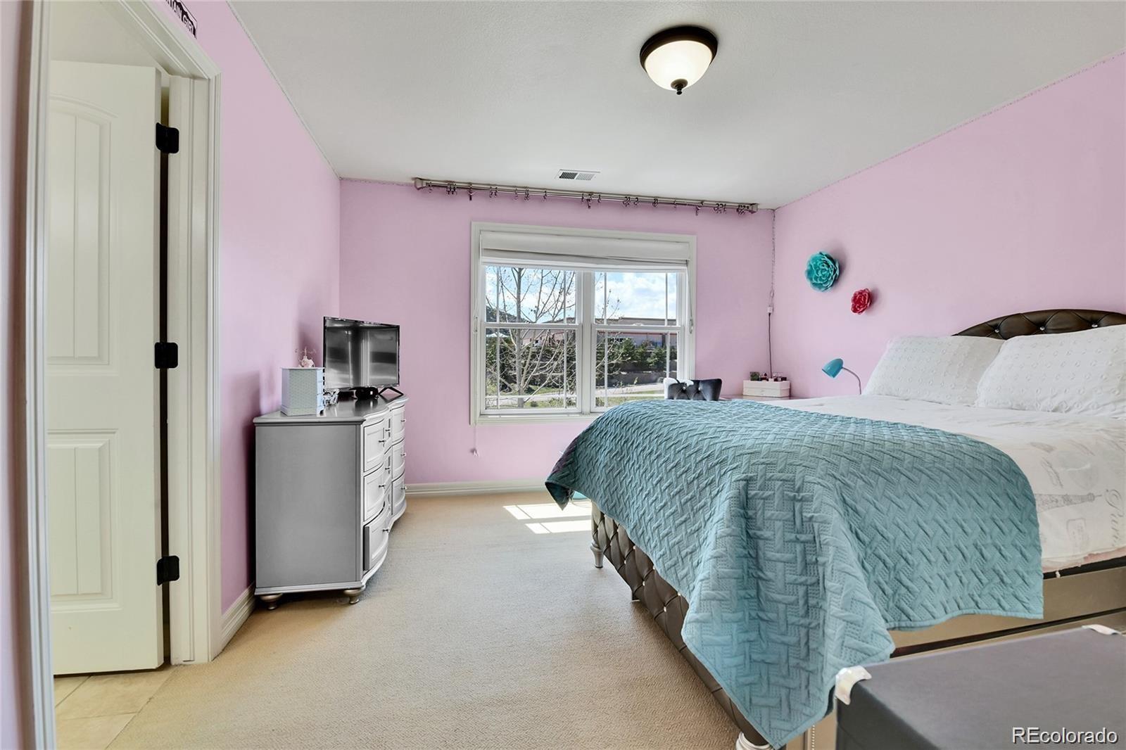 791 Elk Rest Road Evergreen, CO 80439 - Photo 24 of 39 a bedroom with a bed and a large window