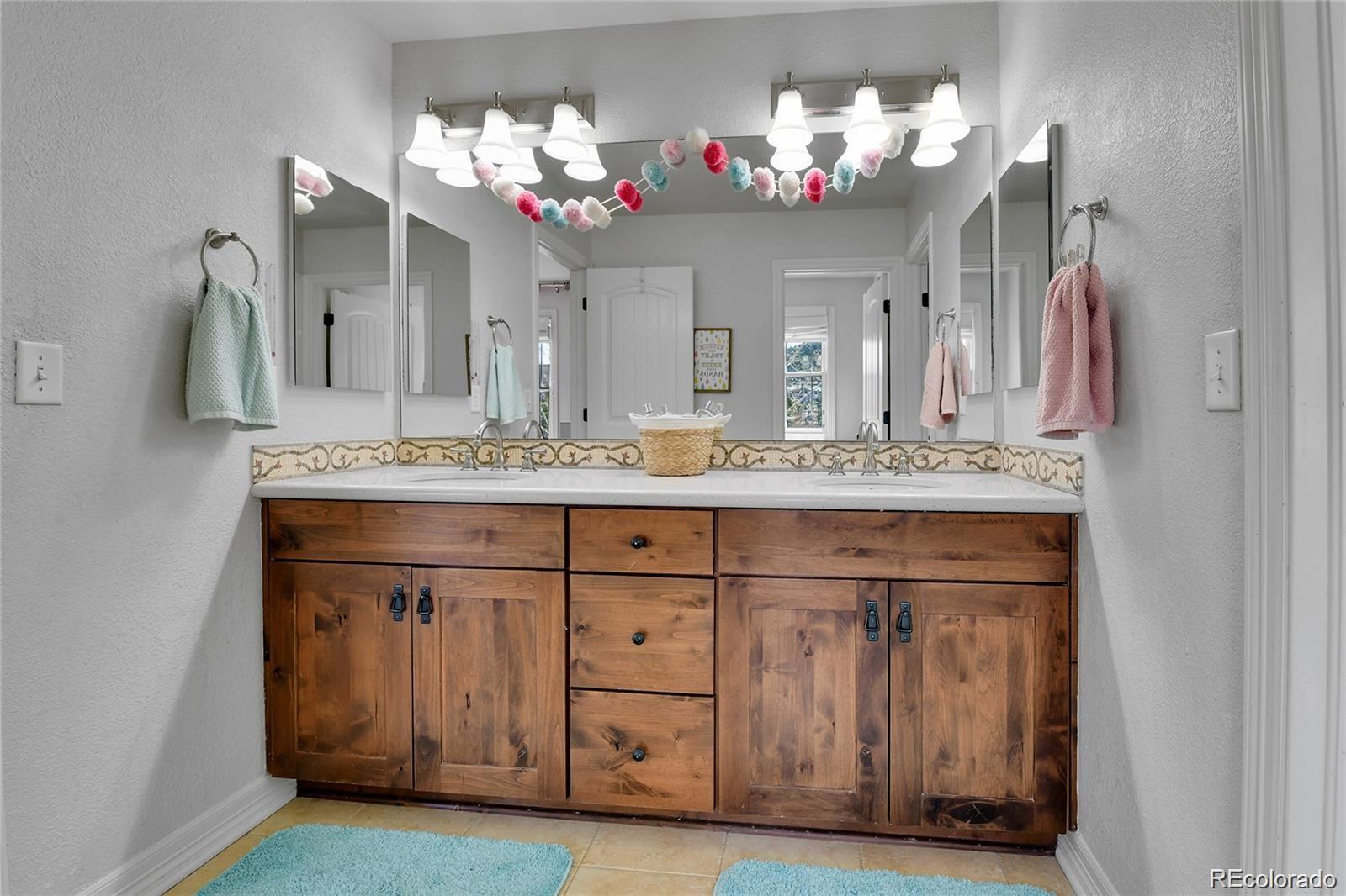 791 Elk Rest Road Evergreen, CO 80439 - Photo 25 of 39 a bathroom with a sink vanity and a mirror