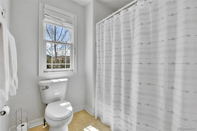 a white toilet sitting next to a shower curtain