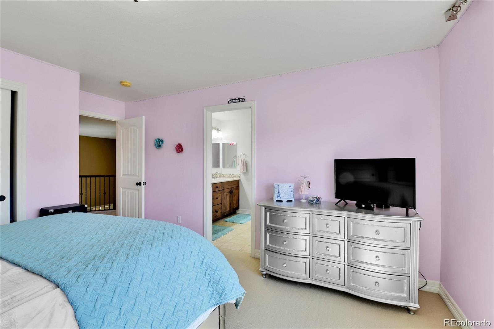 791 Elk Rest Road Evergreen, CO 80439 - Photo 27 of 39 a bed room with a bed and flat screen tv