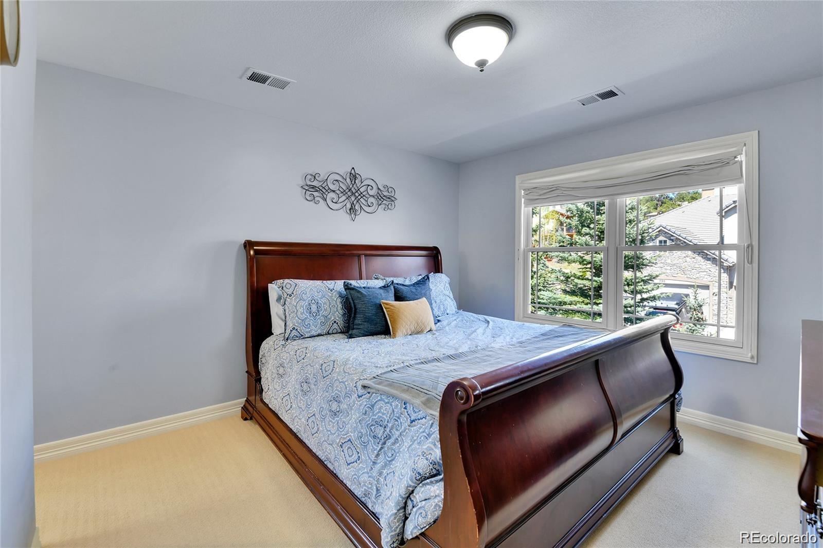 791 Elk Rest Road Evergreen, CO 80439 - Photo 28 of 39 a bed sitting in a bedroom next to a window