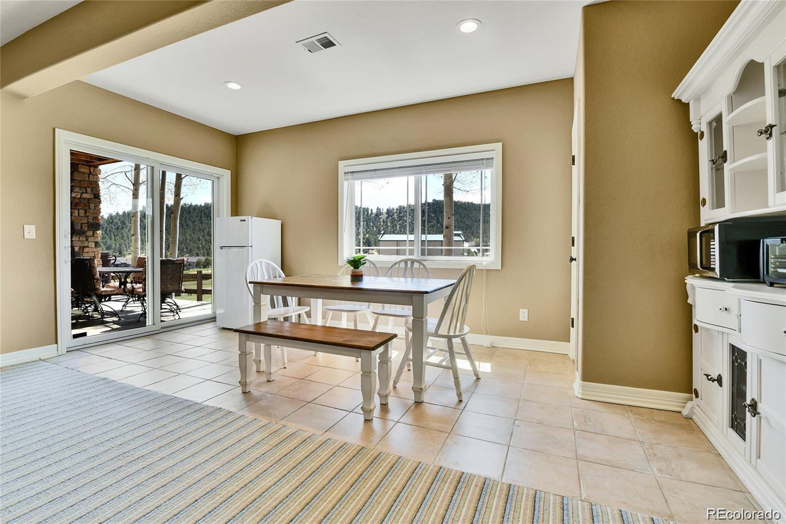 791 Elk Rest Road Evergreen, CO 80439 - Photo 34 of 39 a living room with furniture a large window and wooden floor