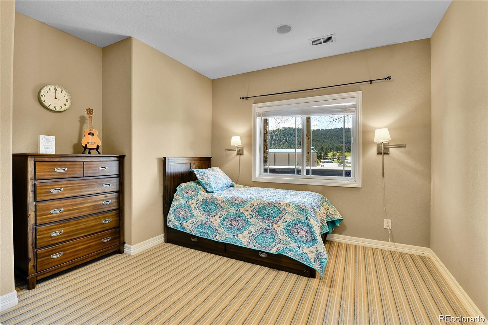 791 Elk Rest Road Evergreen, CO 80439 - Photo 35 of 39 a bedroom with a bed and wooden floor