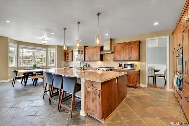 a large kitchen with kitchen island a sink table and chairs