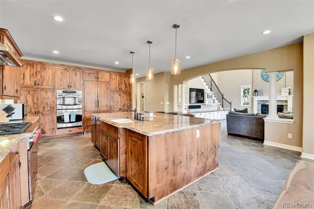 a large kitchen with stainless steel appliances kitchen island granite countertop a large counter top and stove