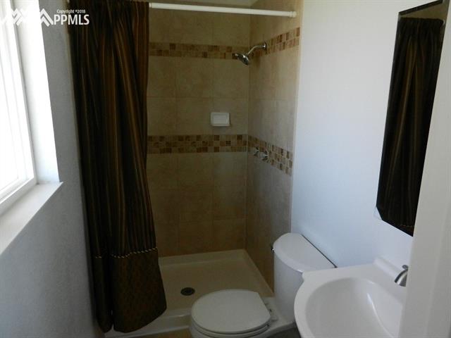 16555 Bar X Road Colorado Springs, CO 80908 - Photo 25 of 36 The master bath has a walk-in shower, new lighting, new toilet and vanity, and new tile.