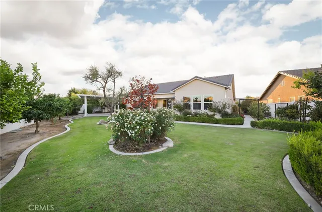 a view of a house with a big yard and a fountain