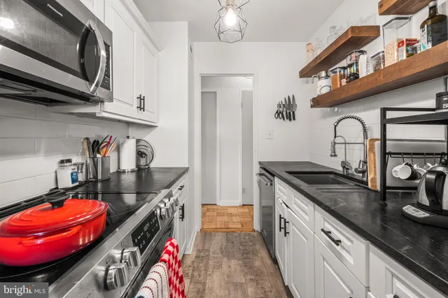 a kitchen with stainless steel appliances granite countertop a stove and cabinets