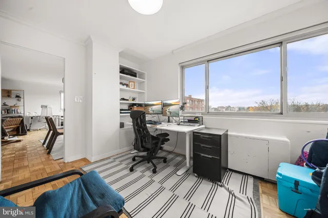 a view of a workspace with furniture and a window