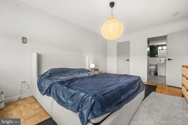 a spacious bedroom with a bed and a chandelier