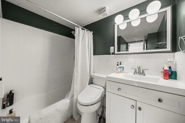a bathroom with a sink vanity mirror and toilet
