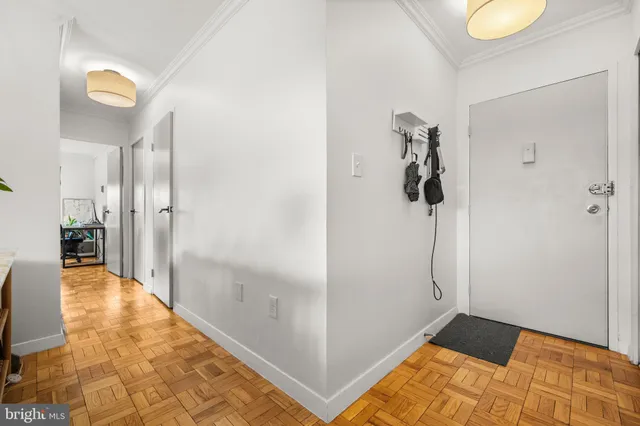 a view of a hallway with wooden floor and a bathroom