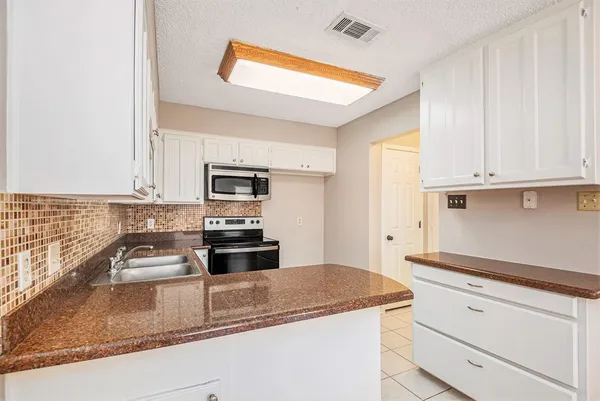 a kitchen with granite countertop stainless steel appliances and white cabinets