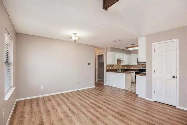 a kitchen with a refrigerator and white cabinets