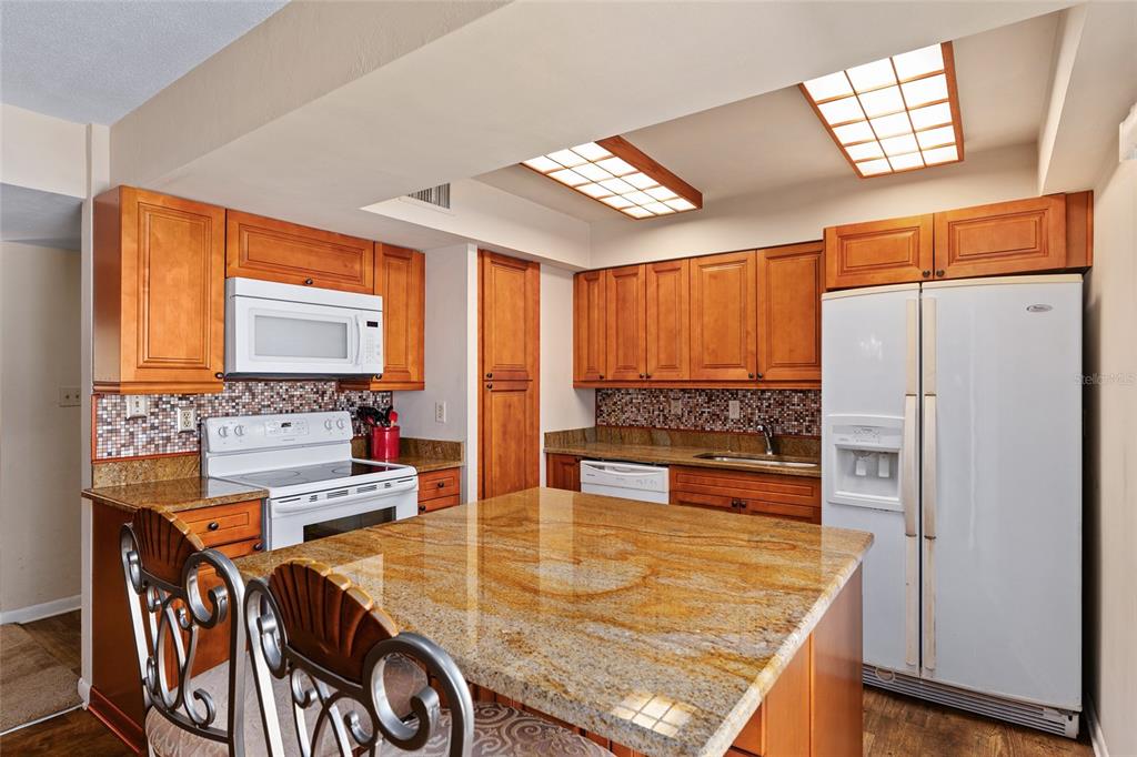 401 Northwest 39th Road, Unit 401C Gainesville, FL 32607 - Photo 12 of 62 a kitchen with stainless steel appliances granite countertop a refrigerator a stove and a sink with cabinets