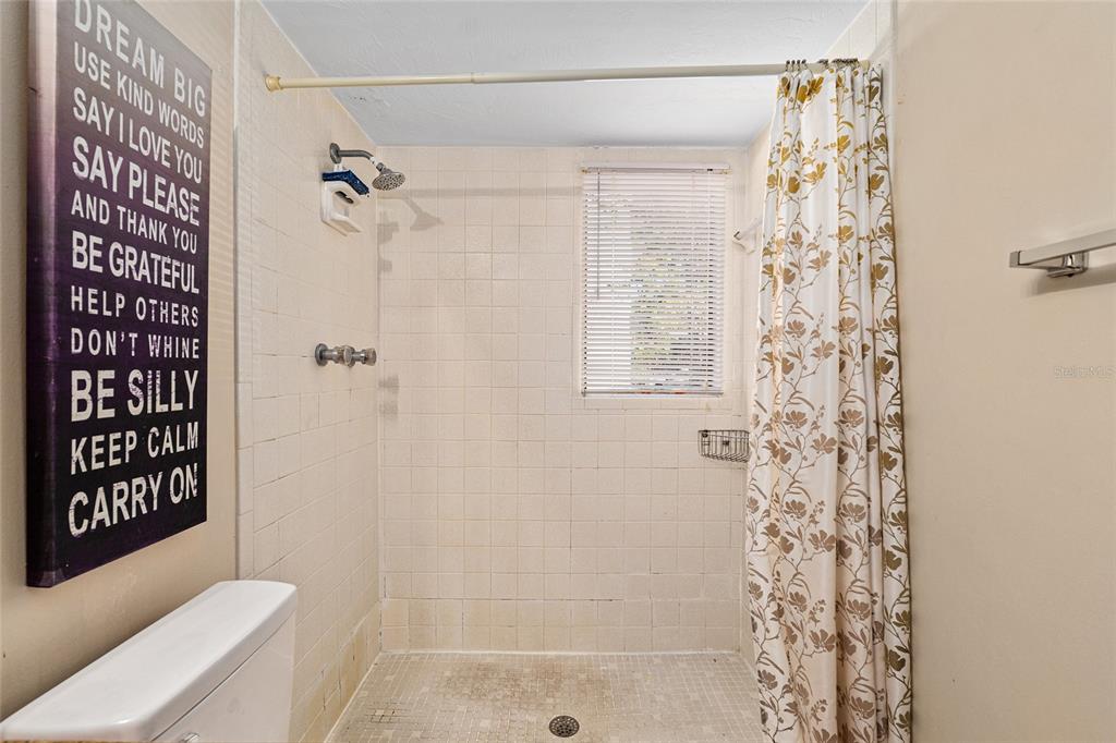 401 Northwest 39th Road, Unit 401C Gainesville, FL 32607 - Photo 30 of 62 a bathroom with a shower curtain and a toilet