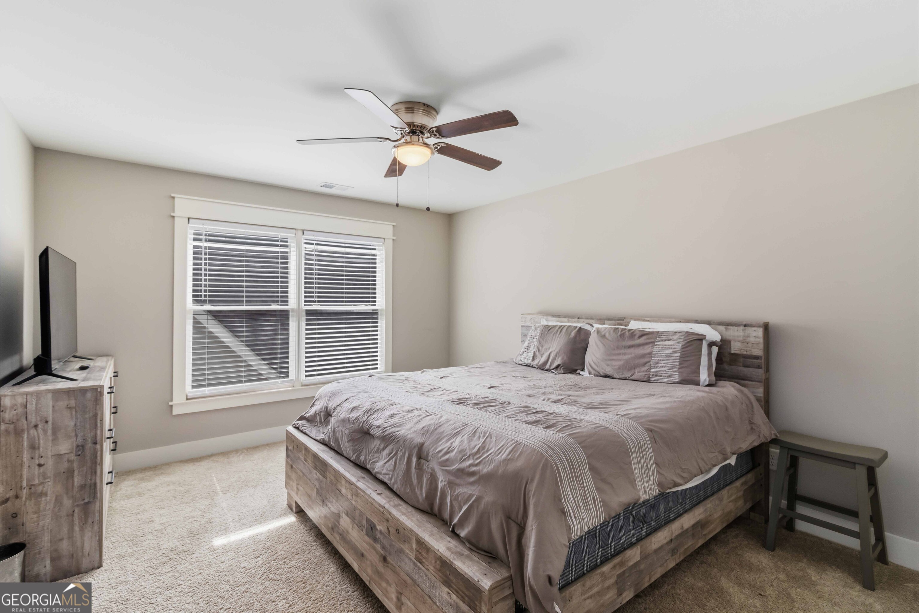 6247 Allen Ivey Road Mableton, GA 30126 - Photo 22 of 31 a bedroom with a large bed and a flat tv screen on dresser