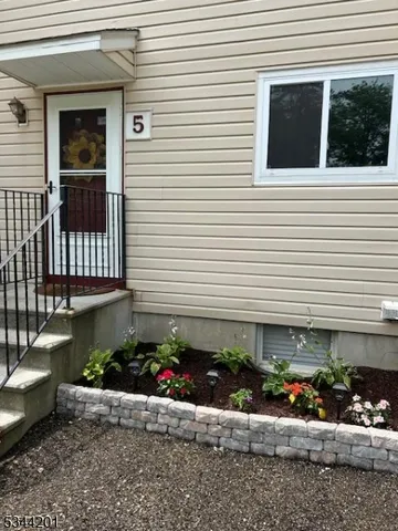 a front view of a house with a garden and flowers